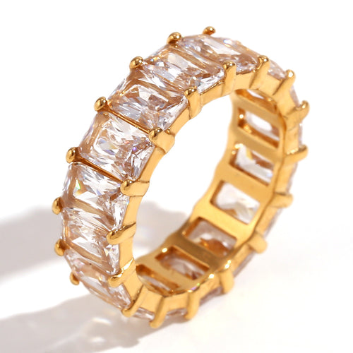 Gold ring with clear gemstones on a white background