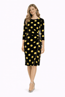 Woman wearing a black dress with yellow polka dots on a white background