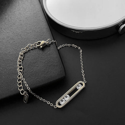 Silver bracelet with a decorative clasp on a dark surface