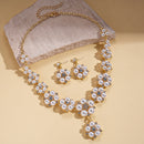 Pearl necklace and earrings set on a beige background