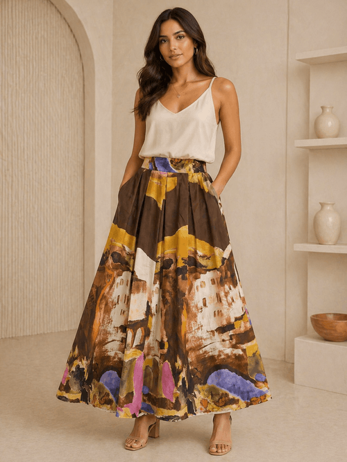 Woman wearing a white top and colorful patterned skirt in a neutral setting