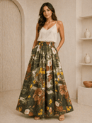 Woman wearing a white top and floral skirt in a neutral setting