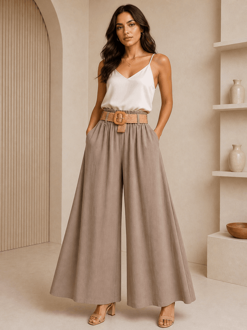 Woman wearing a white top and beige wide-leg pants in a neutral setting