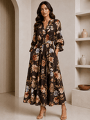 Woman wearing a floral dress in a minimalistic room with shelves.