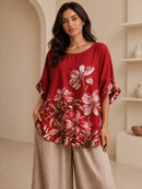 Woman wearing a red floral blouse in a neutral setting
