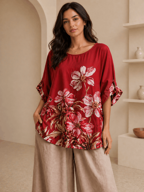 Woman wearing a red floral blouse in a neutral setting
