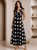 Woman wearing a black dress with white polka dots in an indoor setting.