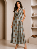 Woman wearing a green dress with brown polka dots in an indoor setting.